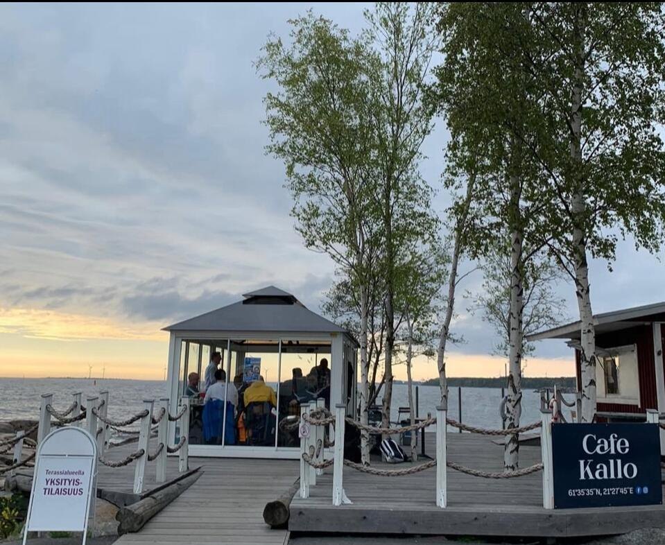 Café Kallon lasipaviljonki ja terassi illansuussa, oikealla Café Kallo -kyltti